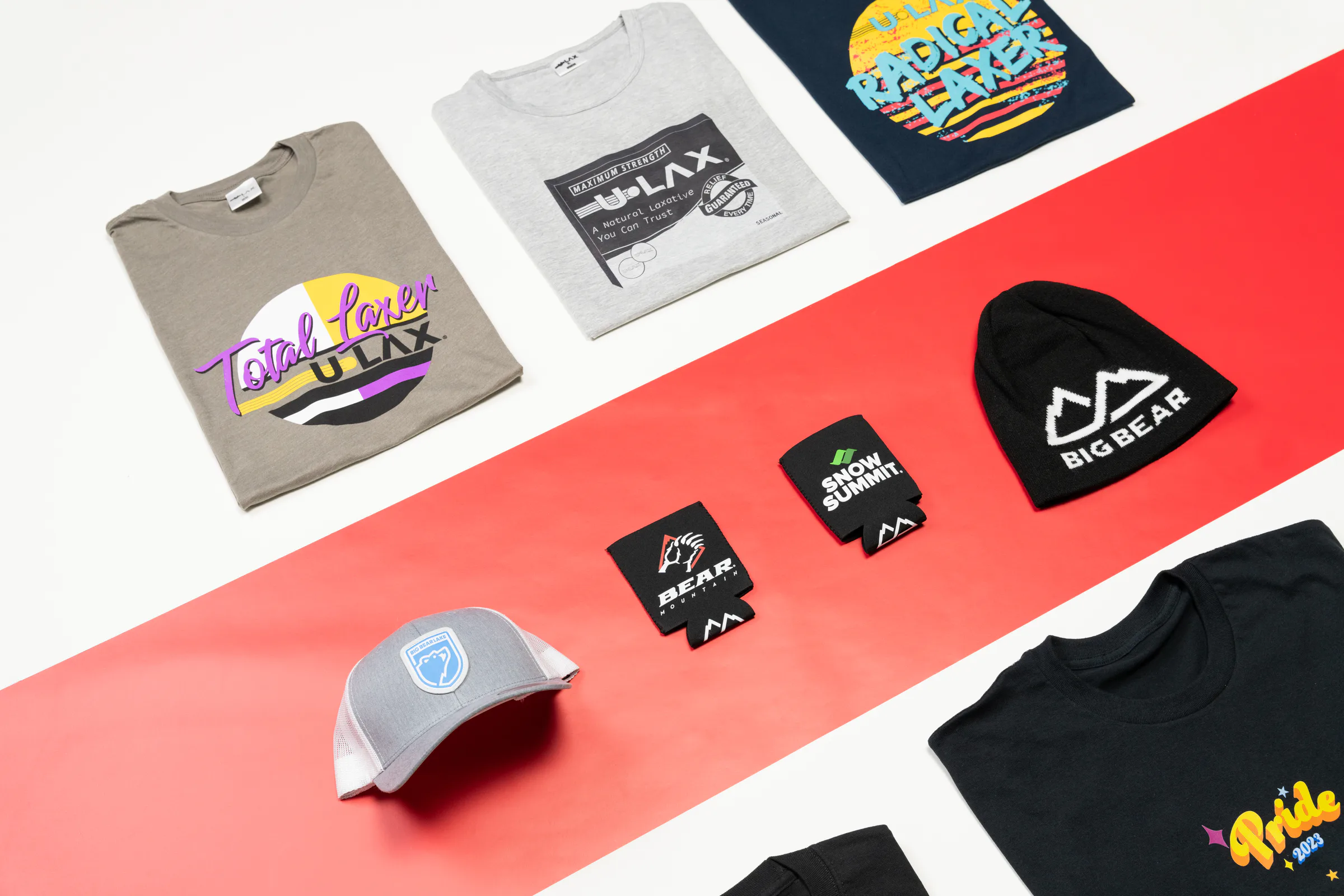 Merch made at Rush: U-LAX tees, a Big Bear beanie and cap, Snow Summit and Bear Mountain koozies and a Pride tee